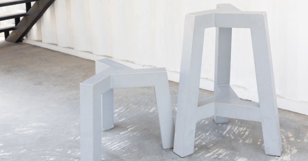 Two modern white three-legged stools 