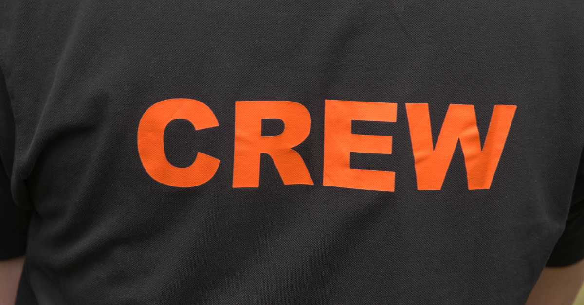 Close up of charcoal black shirt with CREW in orange